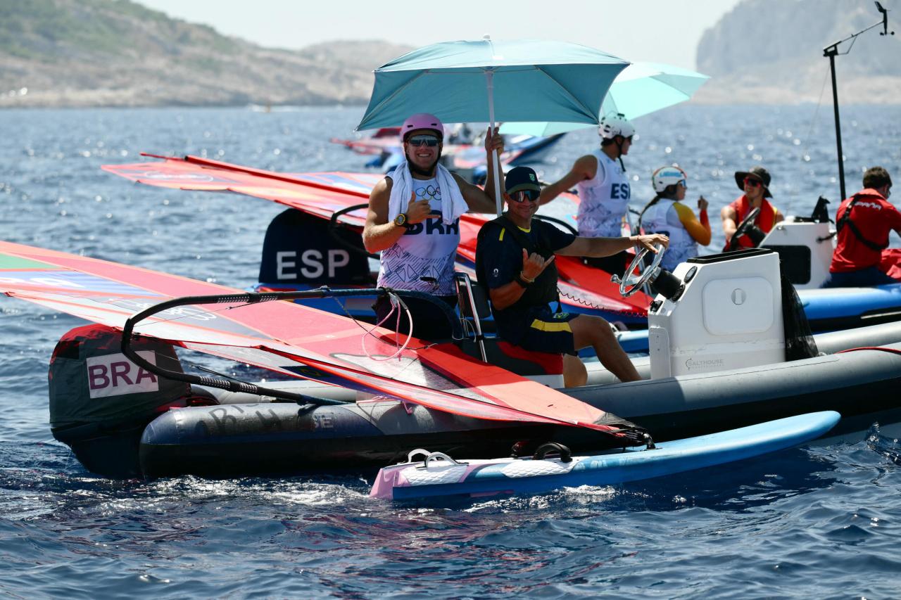 Le Brésilien Mateus Isaac attend de meilleures conditions météorologiques avant une épreuve masculine de planche à voile IQFoil aux JO-2024 au port de plaisance du Roucas-Blanc à Marseille, le 28 juil